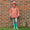 A young girl wearing a Blizzard Kids Ski Jacket Pink, leggings, and wellington boots, standing in front of a brick wall and grass.