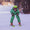 A child in a green Muddy Puddles waterproof ski suit, helmet, and goggles skis down a snowy slope, holding ski poles in both hands.