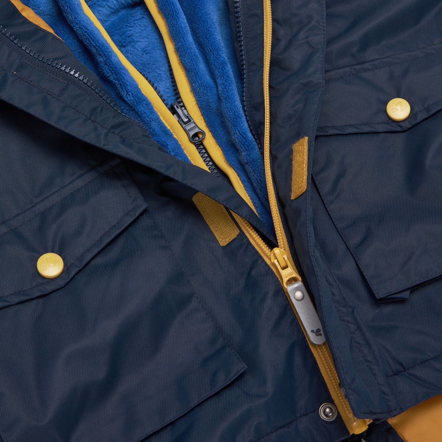 Close up of the '3 in 1 Waterproof Parka Navy' showing the zip and pockets. The jacket is blue with yellow accents.