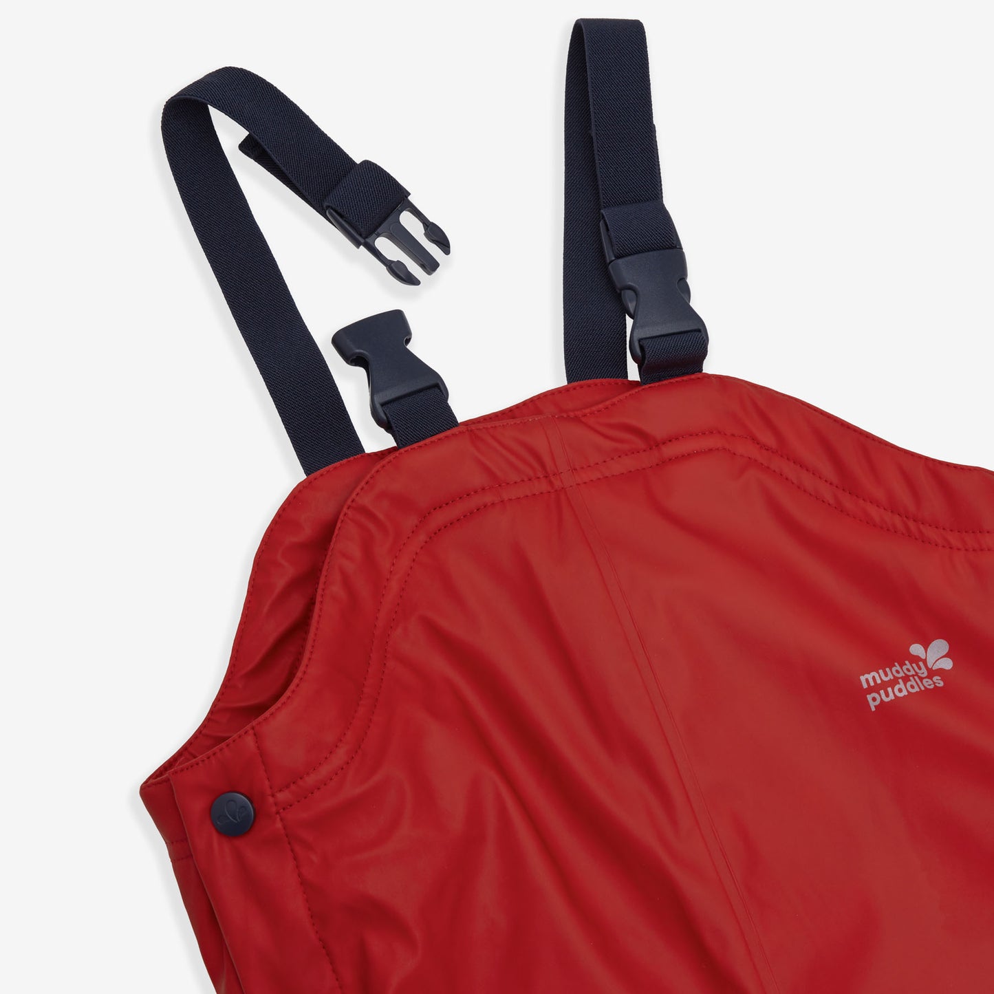 Close-up of red Puddleflex Waterproof Fleece Lined Dungarees, showing navy adjustable straps and Muddy Puddles logo.