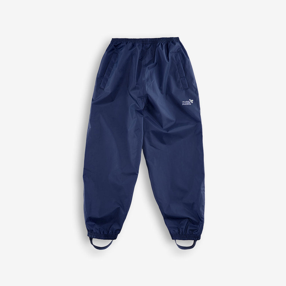 Navy Puddlepac Waterproof Trousers laid out. The trousers are a dark blue, with elasticated waist and stirrups.