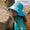 A little girl wears a 'UV Protective Sun Hat Green Ice Cream' by the sea. She is next to some rocks, looking into the distance.