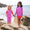 Two children wearing UV Protective Surf Set Pink Starfish, standing on a rock on a beach, smiling at the camera.