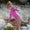A young girl climbing a rock face wearing a UV Protective Long Sleeve Swimsuit Pink Starfish while holding a feather.
