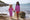 UV Fabrics: Two young girls stand holding hands on a rock at the beach, smiling. They are both wearing matching star-patterned swimwear.