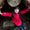 A girl smiles in a den wearing a red Puddleflex Waterproof Fleece Lined Jacket, jeans and black boots.