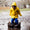 A child in a Puddleflex Waterproof Fleece Lined Jacket Yellow jumps in a muddy puddle, splashing water everywhere.