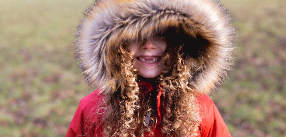 close up of girl wearing red parka jacket with faux fur hood
