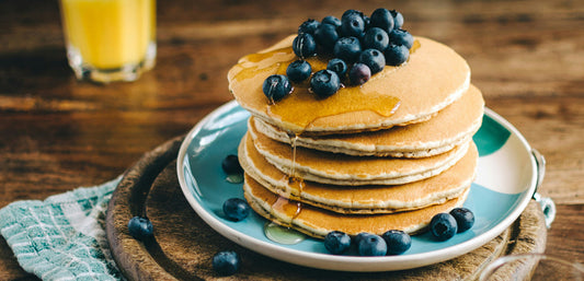 pancakes with blueberries and syrup, photo by Calum Lewis on Unsplash