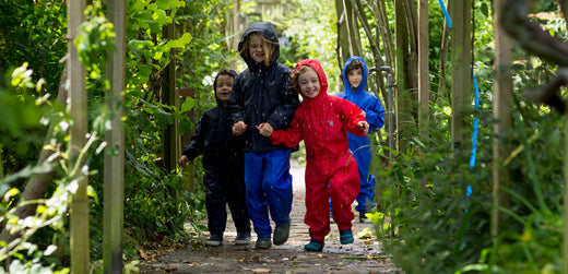 children wearing vibrant muddy puddles waterproofs, running in the rain