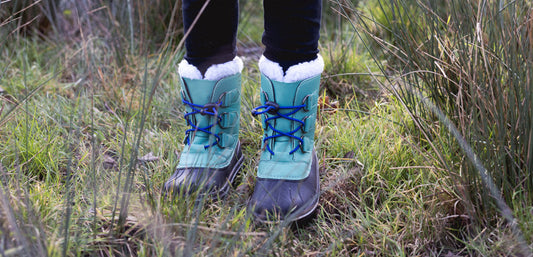 child wearing green fleece lined snowboots