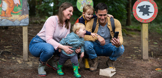 Family with children in waterproof outdoor clothing taking a selfie in a forest