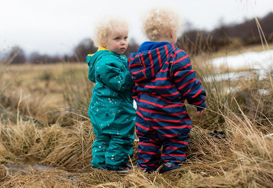 toddler boys stood in heathland, wearing vibrant muddy puddles puddlesuits