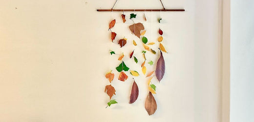 DIY kids autumn leaf mobile with colorful leaves hanging on wall indoors