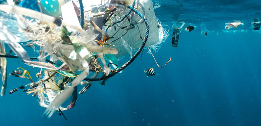 Plastic pollution floating underwater with fish in a blue ocean setting