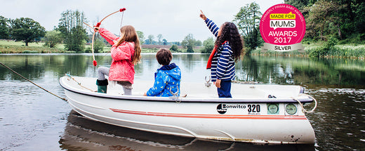 children on a motor boat wearing muddy puddles waterproof jackets, made for mums awards logo in the corner