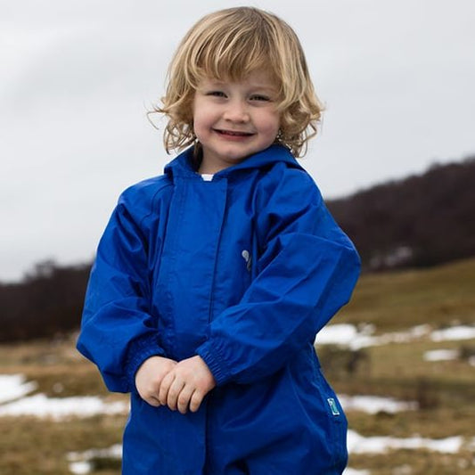 boy stood in wet heathland, wearing blue muddy puddles puddlesuit