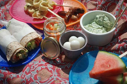 selection of healthy picnic food on a patterned picnic blanket