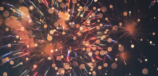 Colorful fireworks exploding against a dark night sky at an outdoor event