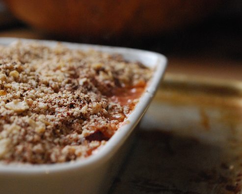 close up of rhubarb and date crumble in a white dish