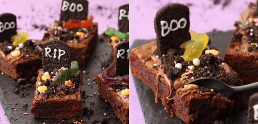 Halloween brownies decorated with cookie tombstones, candy pumpkins, and sprinkles on slate