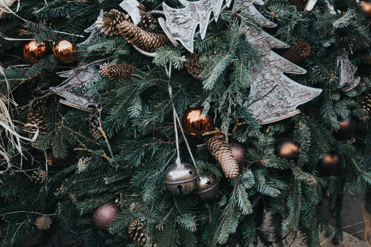 close up of a christmas tree with bells, baubles and pine cones