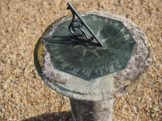 stone sundial surrounded by gravel