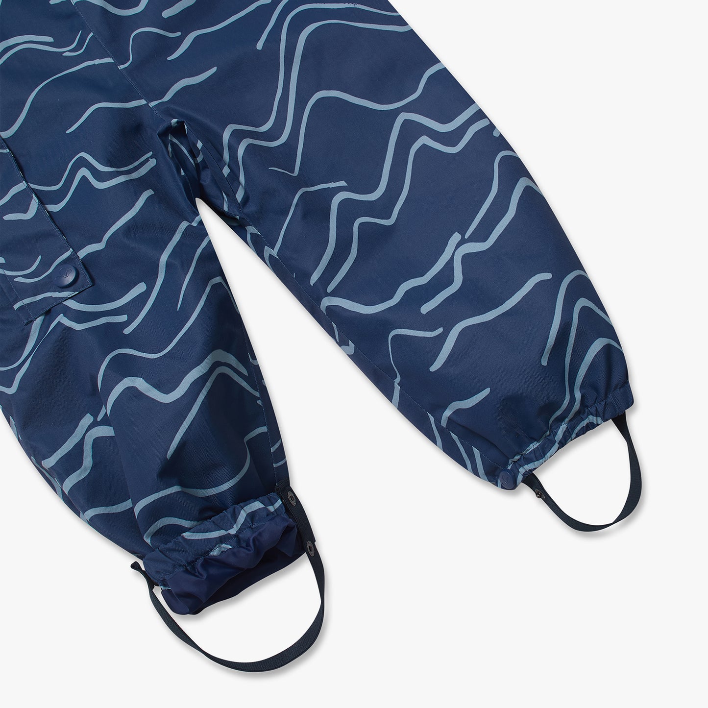 3 in 1 Waterproof Scampsuit Blue Mountains, featuring durable, waterproof over-pants with wavy patterns, elastic cuffs, and adjustable stirrups for secure fit over boots.