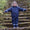 a child wearing a puddleflex waterproof puddle suit going down some outdoor stairs