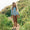 A girl on a path wearing a UV Protective Long Sleeve Swimsuit Multi Stripe, surrounded by grasses and wildflowers on a sunny day.