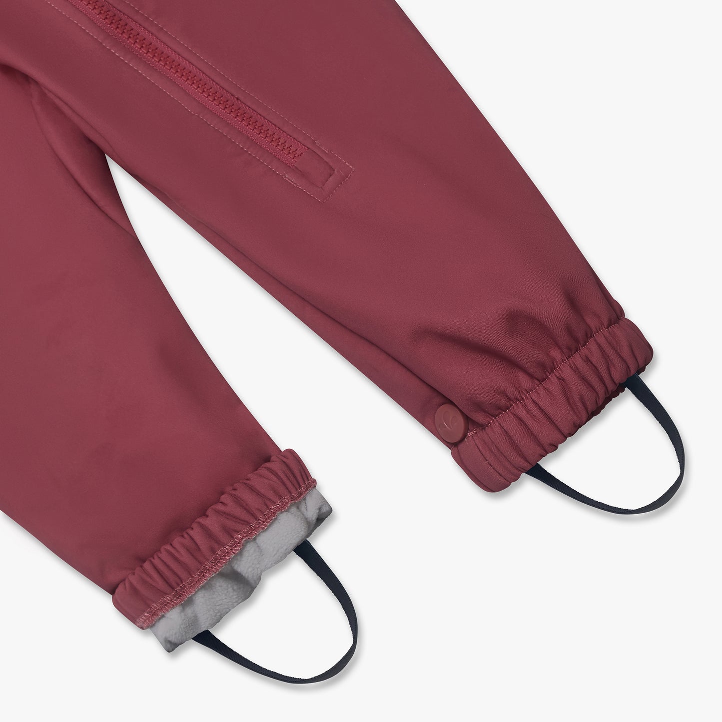 Child's Waterproof Softshell Puddle Suit Pink with elasticized cuffs, light gray fleece lining, and under-foot stirrups for secure fit; features a zippered pocket detail.